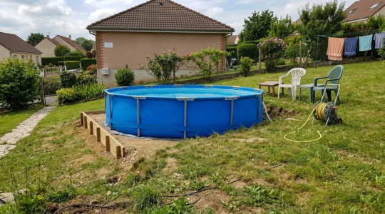 Vue d'ensemble d'une piscine tubulaire installée sur un terrain légèrement en pente, avec indication visuelle du dénivelé et des zones de stabilisation